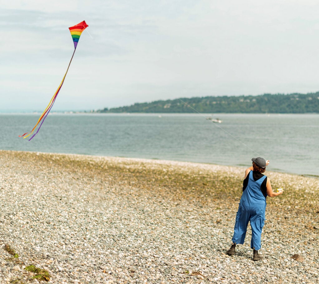 Lindsay flying a kite on a beach